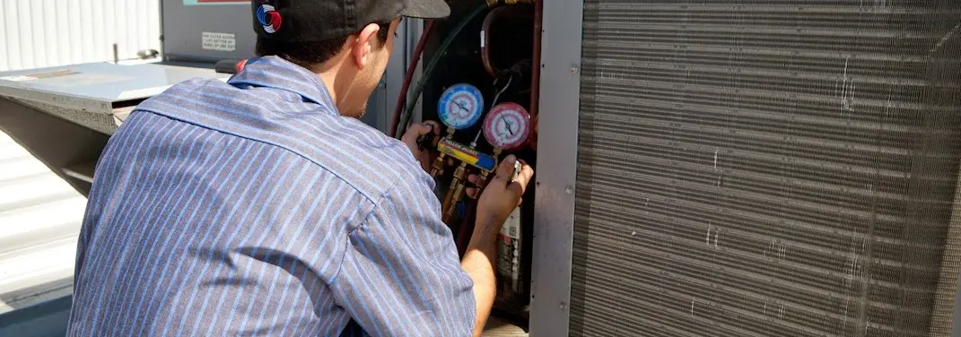 HVAC technician servicing a condenser unit in Port Wentworth